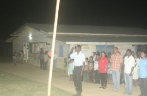 A police rank prepares to hoist the flag at the ceremony at Kurukubaru, Region Eight