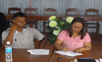 Hon. Pauline Sukhai affixes her signature as Toshao of Waicarabi looks on.