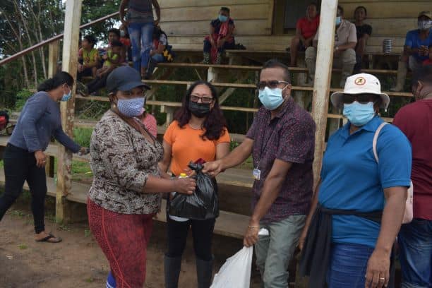 Minister Sukhai and team hands over hampers to a resident of El Paso Village.