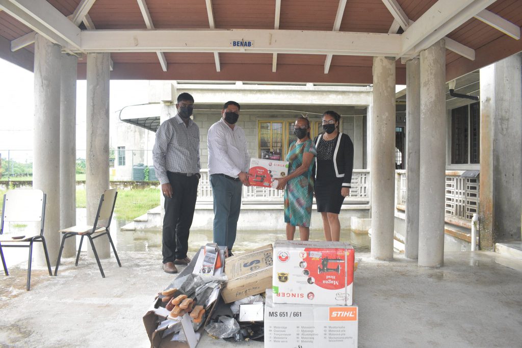 Deputy Permanent Secretary, Ryan Toolsiram handing over the tools and equipment to Toshao Yvonne Pearson in the presence of Parliamentary Secretary Sarah Browne and Project Coordinator Besham Ramsaywack