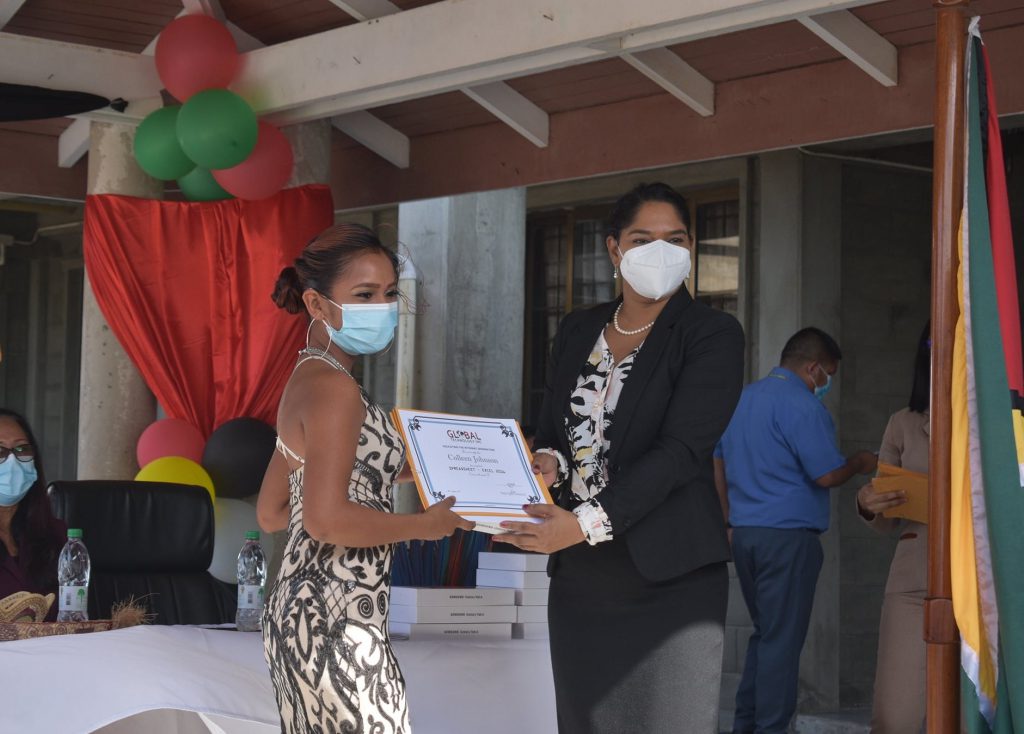 Hon. Minister Sonia Parag presents a graduate with a certificate and tablet