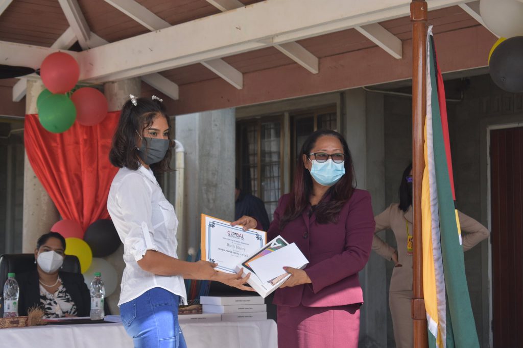 Hon. Minister Pauline Sukhai presents a certificate, and tablet to a graduate of Laluni Village.