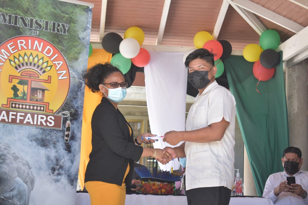 Permanent Secretary at the Ministry of Amerindian Affairs, Sharon Hicks hands over a certificate to a graduating community service officer 