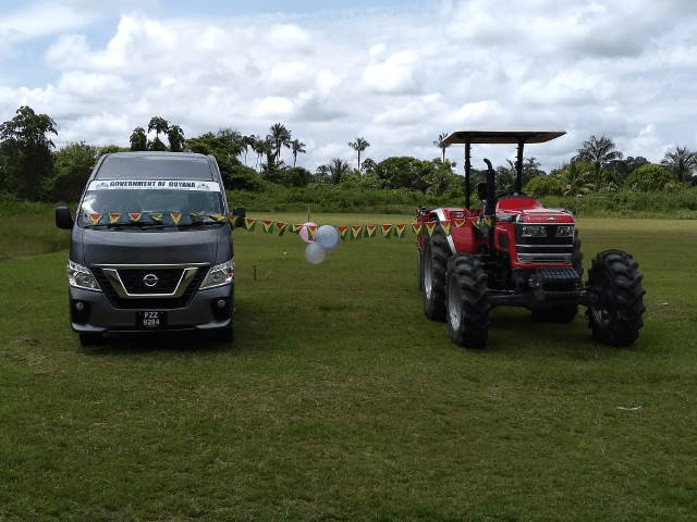 The brand new bus and tractor that were handed over to the village of Fairview, Region Eight